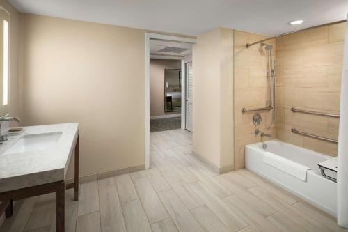 a bathroom with a tub and a toilet and a sink at Hilton Santa Barbara Beachfront Resort in Santa Barbara