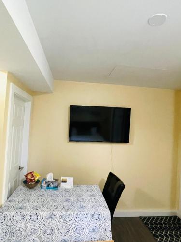 a room with a table and a television on a wall at Garden home in Victoria in Victoria