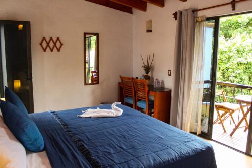 Un dormitorio con una cama azul con un cisne. en Posada El Canto del Cenzontle, en Tepoztlán