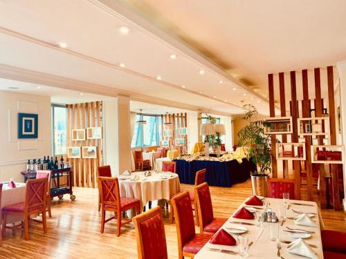 Golden Addis Hotel في أديس أبابا: مطعم فيه طاولات وكراسي في الغرفة