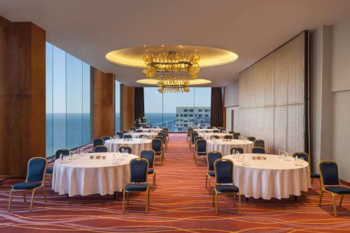 um salão de banquetes com mesas e cadeiras e um lustre em Radisson Hotel Colombo em Colombo