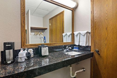 bagno con lavandino e specchio di Rodeway Inn a McPherson