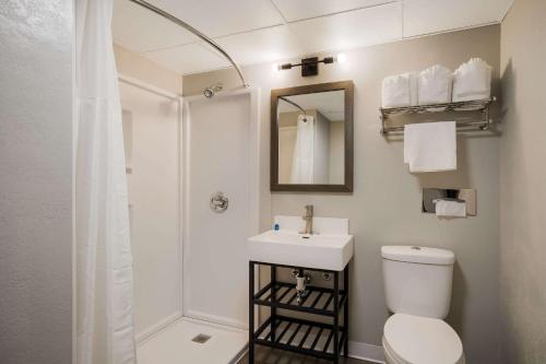 La salle de bains est pourvue d'une douche, de toilettes et d'un lavabo. dans l'établissement Suburban Studios Milwaukee Airport, à Milwaukee