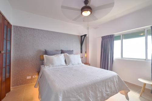 a bedroom with a white bed and a window at Villa Marbella by Potenza Rentals in Santo Domingo