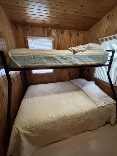 a bedroom with two bunk beds in a cabin at Carry Bay Cottage #1 in North Hero