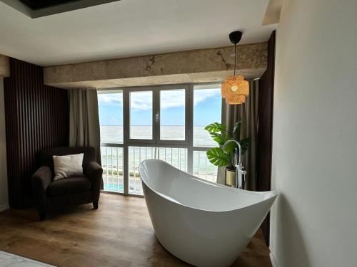 a bathroom with a white tub in front of a window at Villa Marbella by Potenza Rentals in Santo Domingo