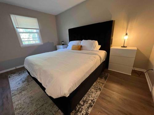 - une chambre avec un grand lit blanc et une table de nuit dans l'établissement Oasis Of Maple Grove, à Maple Grove