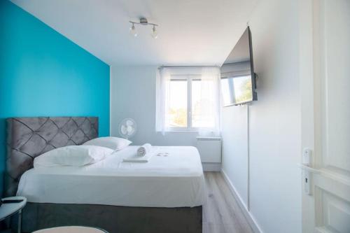 une chambre avec un grand lit avec un mur bleu dans l'établissement Sablier T4 parking dans une residence securisee, à Marseille