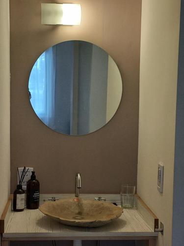 a bathroom with a sink with a circular mirror at Delta Home II in San Carlos de Bariloche