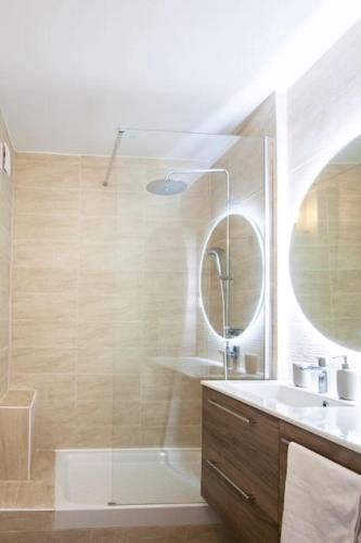 une salle de bain avec une douche, un lavabo et un miroir dans l'établissement Sablier T4 parking dans une residence securisee, à Marseille