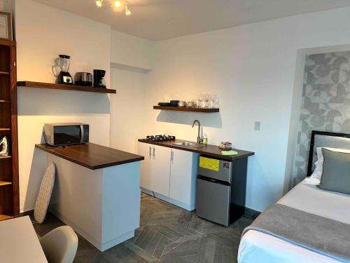 a small room with a bed and a kitchen with a sink at Villa Marbella by Potenza Rentals in Santo Domingo