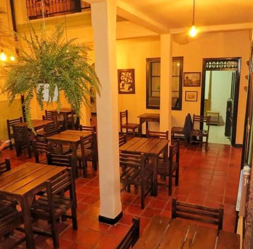 an empty restaurant with wooden tables and chairs at Hostal Belén in Popayan