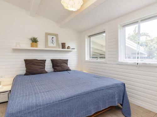 Un dormitorio con una cama azul y una ventana en Holiday home Stege IV, en Stege