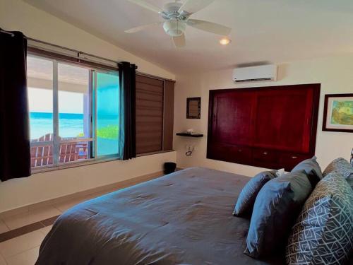 a bedroom with a bed with a view of the ocean at Beach Bliss Bungalow - Amazing pool in Chelem