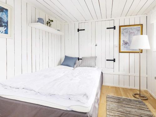 un letto bianco in una stanza con pareti bianche di Holiday home Karrebæksminde IX a Karrebæksminde