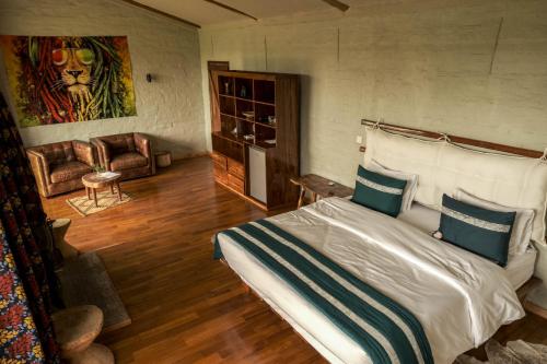 1 dormitorio con cama extragrande y sofá en Kiho Gorilla Safari Lodge, 