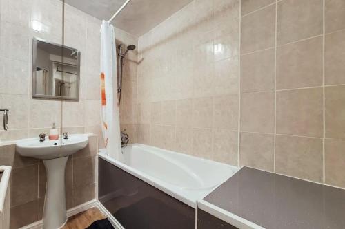 a bathroom with a sink and a bath tub and a toilet at Regent's Park Apartment in London