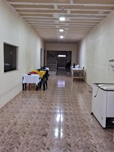 ein Zimmer mit Tischen und Stühlen in einem Gebäude in der Unterkunft POUSADA LUMI in Alter do Chao