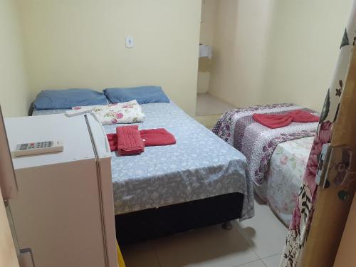 Kleines Zimmer mit 2 Betten und einem Kühlschrank. in der Unterkunft POUSADA LUMI in Alter do Chao