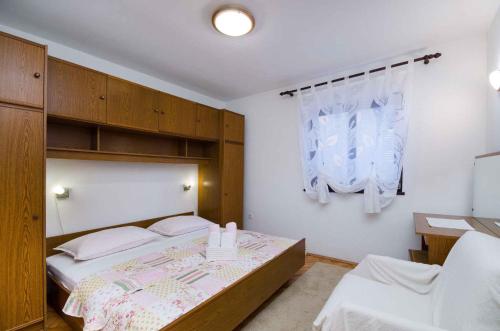 - une chambre avec un grand lit et une fenêtre dans l'établissement One-Bedroom Apartment in Crikvenica 7, à Crikvenica
