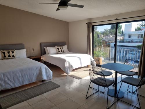 1 dormitorio con 2 camas, mesa y balcón en Casa Victorias en Guadalajara