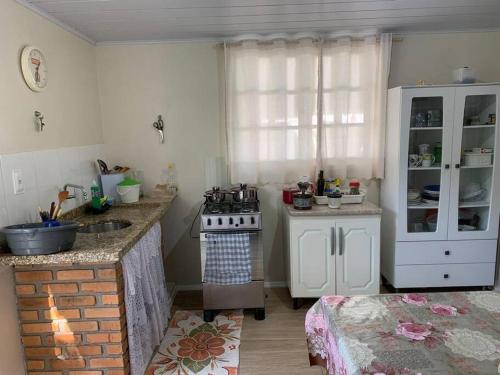 uma cozinha com um fogão e um lavatório em Refúgio Andrade em Governador Celso Ramos