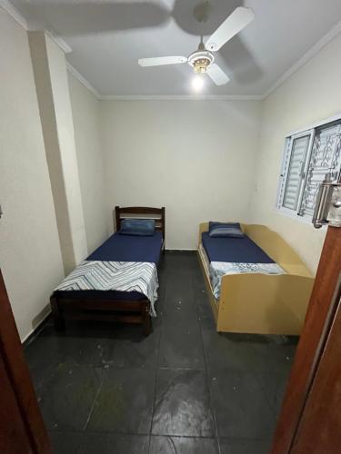 two beds in a room with a ceiling fan at Albuquerque nro36 casa 3 in Campinas