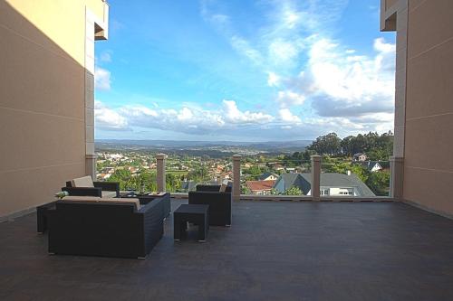 a balcony with couches and a view of a city at Hotel Os Olivos in Guísamo