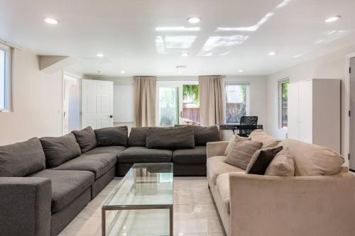 uma sala de estar com um sofá e uma mesa de vidro em Spacious 5 BR Brand New HouseLAX/ SoFi/Kia/SpaceX/ em Inglewood