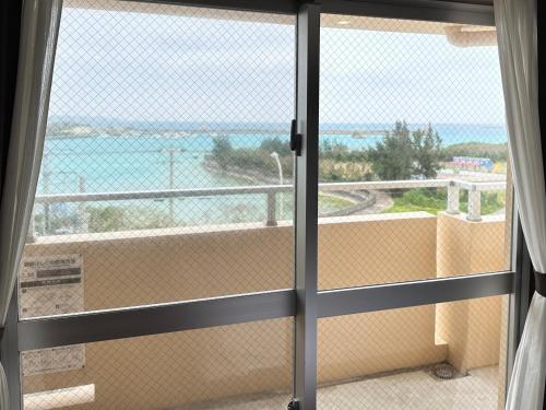 a room with a view of the ocean from a window at Hotel Miyakojima in Miyako Island
