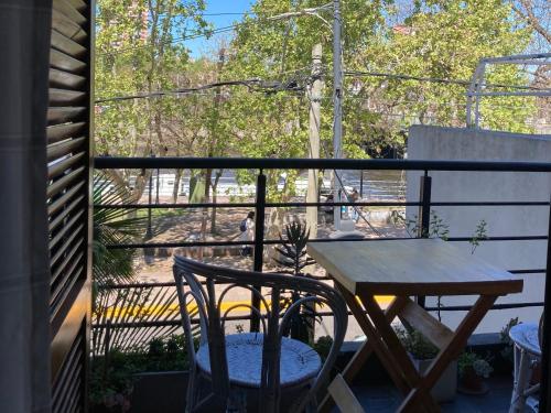 y balcón con mesa y sillas de madera. en Tigre Apartment en Tigre