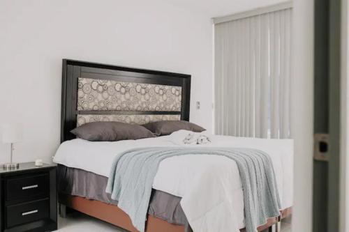 a bedroom with a large bed with a black headboard at Amplia Casa Moderna c/ Piscina y Lindos Jardines 