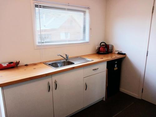 a kitchen counter with a sink and a window at Delightful Lake Hawea Cabin with Mountain Views in Lake Hawea