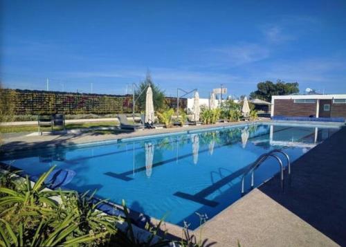 a large swimming pool with blue water at Amplia Casa Moderna c/ Piscina y Lindos Jardines in Trojes de Alonso