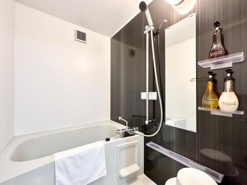 a bathroom with a tub and a toilet and a sink at Hotel Miyakojima in Miyako Island