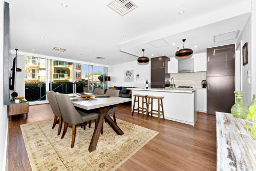 a kitchen and dining room with a table and chairs at Belle Escapes - Beach Retreat Townhouse Glenelg in Glenelg