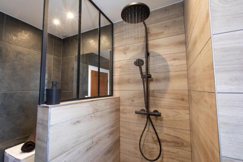 une douche dans une salle de bain avec un mur en bois dans l'établissement Refuge Ladhof Odysalis I Chic-Moderne-Proche du centre-ville 3 pieces 2 Chambres, à Colmar