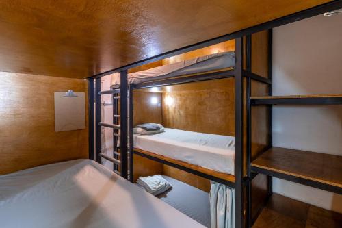 Akih Pods Hostel في شاطئ سانتا تيريزا: سريرين بطابقين في غرفة
