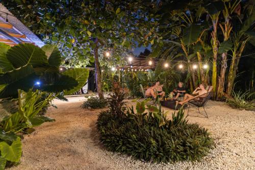 a group of people sitting in chairs on the beach at night at Akih Pods Hostel in Santa Teresa Beach