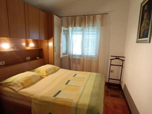 a bedroom with a large bed with a window at Apartments by the sea Necujam, Solta - 21776 in Grohote