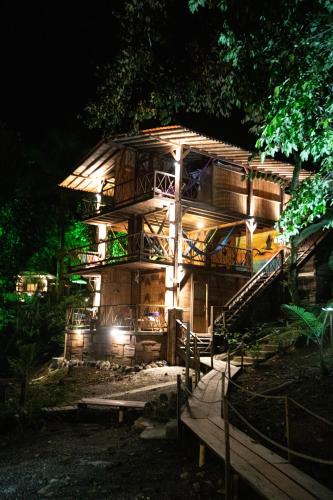 a large wooden building with a lit up facade at night at La Martina Ecolodge in Nuquí