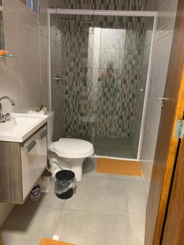 a bathroom with a shower and a toilet and a sink at Canto Gira Sol - Suíte Flor in Penha