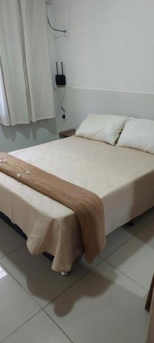 a bed with a blanket on it in a room at Apê Aconchegante in Recife