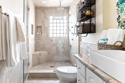 a white bathroom with a shower and a toilet at Pick from Curated Vintage Vinyl 3B-2B Lic 65597 in La Quinta