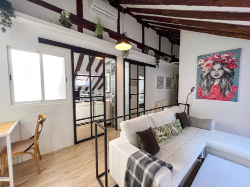 un salon avec un canapé blanc et une table dans l'établissement Callao Suites, à Madrid