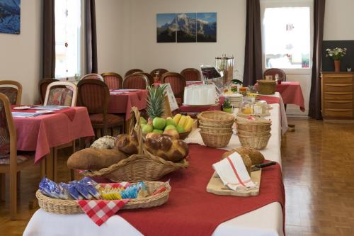 a table with baskets of fruits and vegetables on it at Hotel Bel-Air Eden in Grindelwald