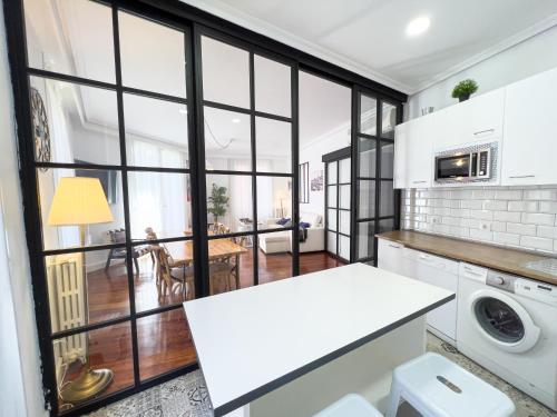 une cuisine avec des appareils blancs et une grande fenêtre dans l'établissement Callao Suites, à Madrid