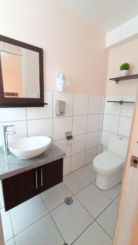 a white bathroom with a sink and a toilet at MADA Guest House Puno "Hospedaje" in Puno
