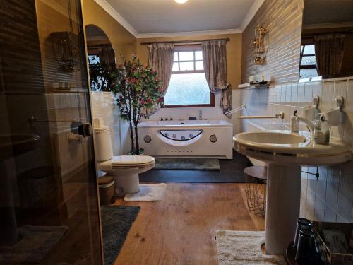 a bathroom with a sink and a toilet and a tub at Bogenraith House in Banchory