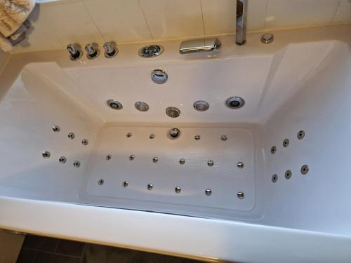 a white bath tub with silver knobs on it at Bogenraith House in Banchory